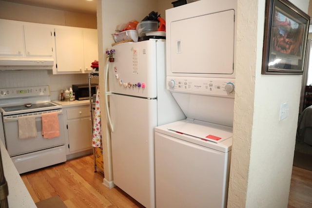 kitchen featuring stacked washer and clothes dryer, white cabinets, light hardwood / wood-style floors, and white appliances