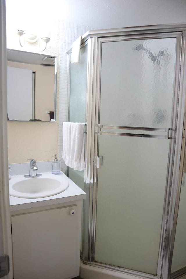 bathroom with a shower with door and vanity