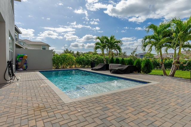 view of swimming pool with pool water feature and a patio