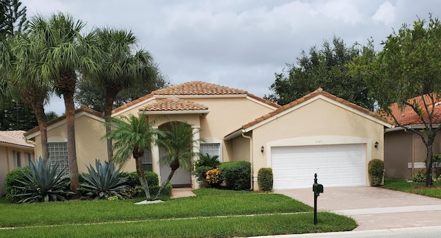 mediterranean / spanish house with a garage and a front lawn