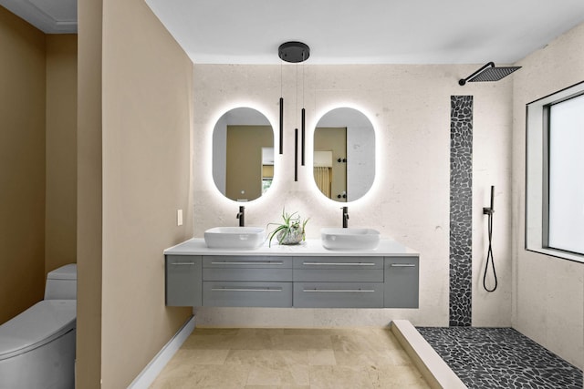 bathroom with tiled shower, vanity, and toilet