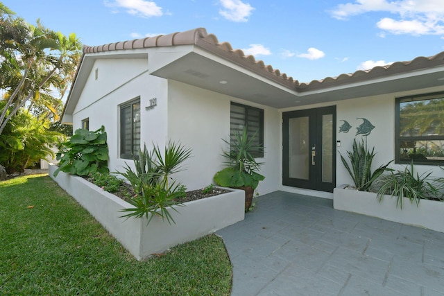 view of exterior entry with a patio area and french doors