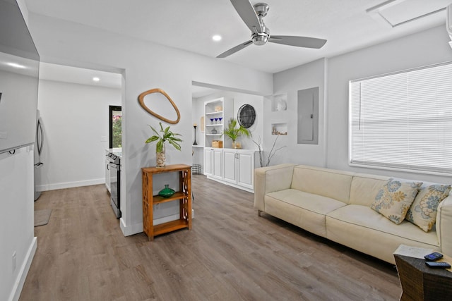 living room featuring electric panel, hardwood / wood-style flooring, and ceiling fan