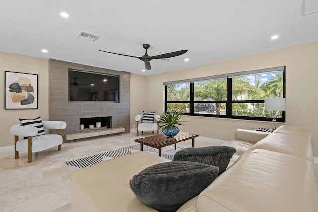 living room featuring a fireplace and ceiling fan