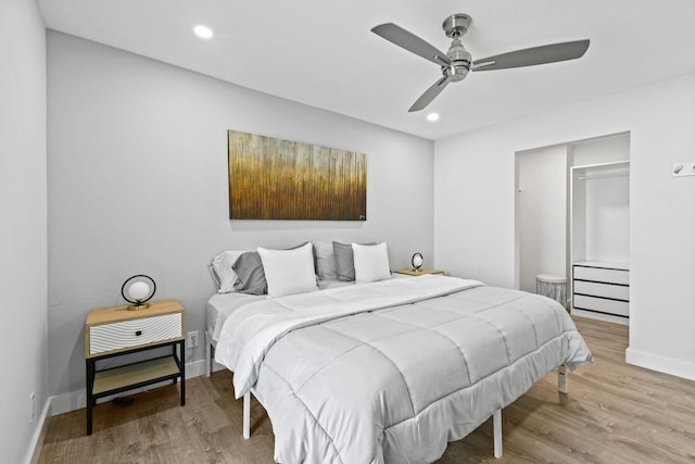 bedroom featuring ceiling fan, a closet, and light hardwood / wood-style flooring