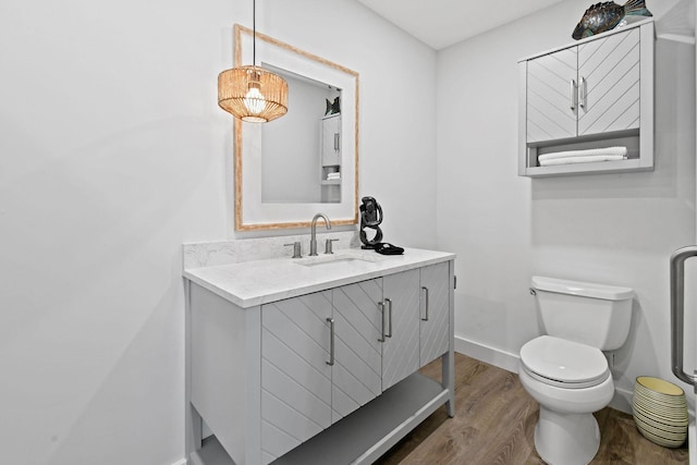 bathroom with hardwood / wood-style floors, vanity, and toilet