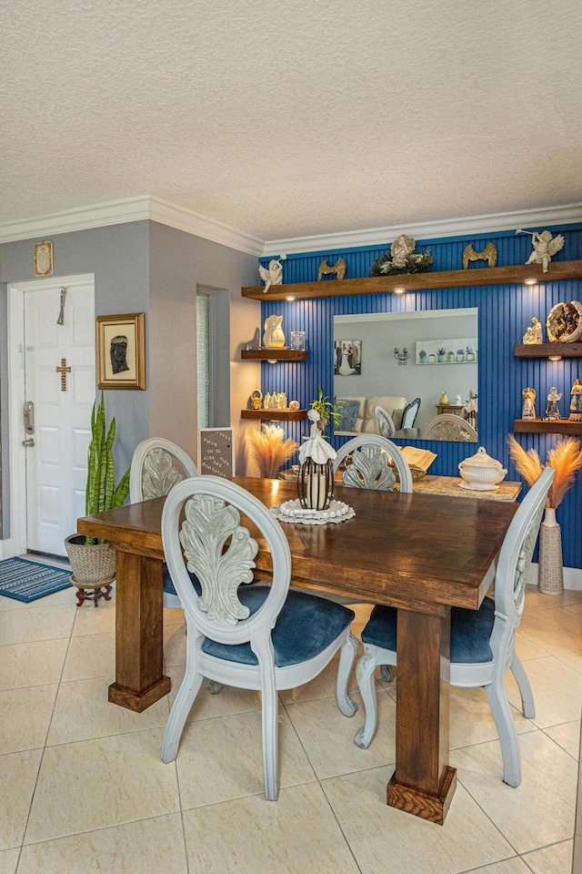 dining space featuring a textured ceiling, tile patterned floors, and ornamental molding