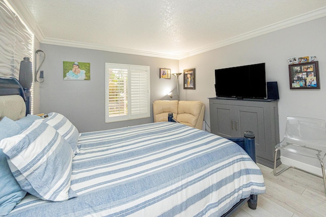 bedroom with crown molding and light hardwood / wood-style floors