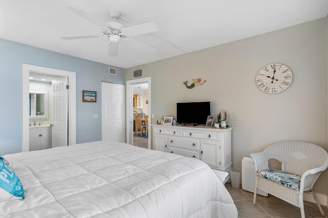 bedroom with ceiling fan, sink, light tile patterned floors, and ensuite bathroom