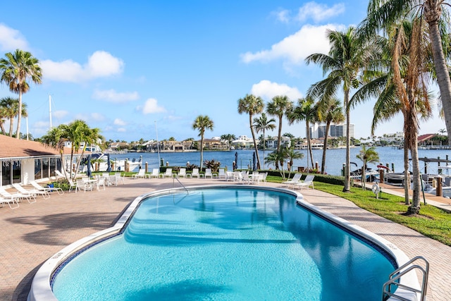 view of pool featuring a water view and a patio area