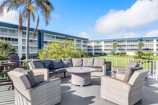 view of patio with an outdoor living space with a fire pit