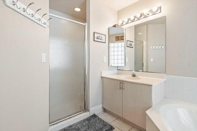 bathroom with shower with separate bathtub, vanity, and tile patterned floors