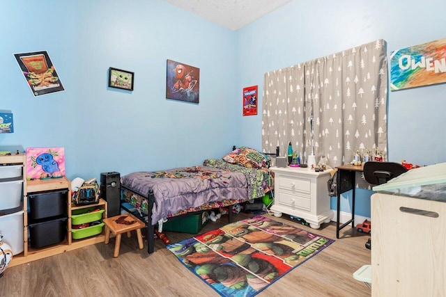 bedroom featuring a textured ceiling and light wood-type flooring