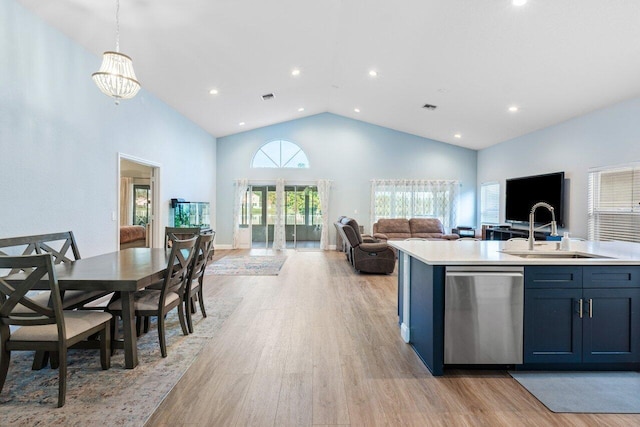 kitchen with high vaulted ceiling, sink, light hardwood / wood-style flooring, stainless steel dishwasher, and decorative light fixtures