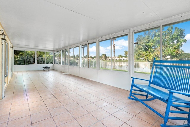 unfurnished sunroom featuring plenty of natural light and a water view