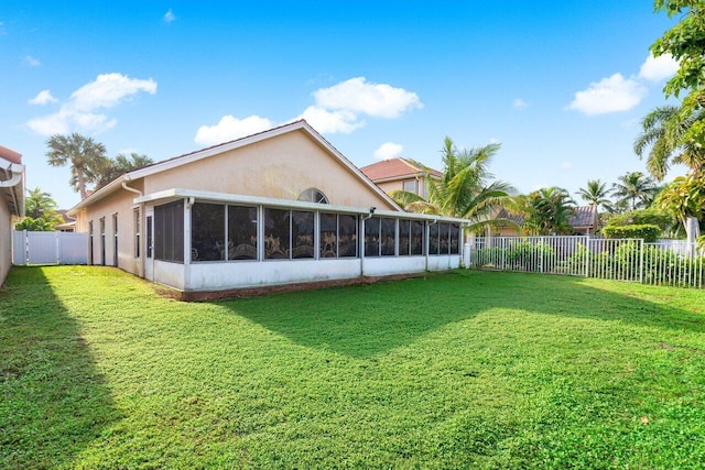 back of house featuring a sunroom and a yard