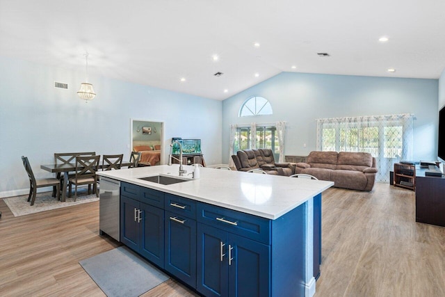 kitchen featuring dishwasher, a center island with sink, blue cabinets, and sink