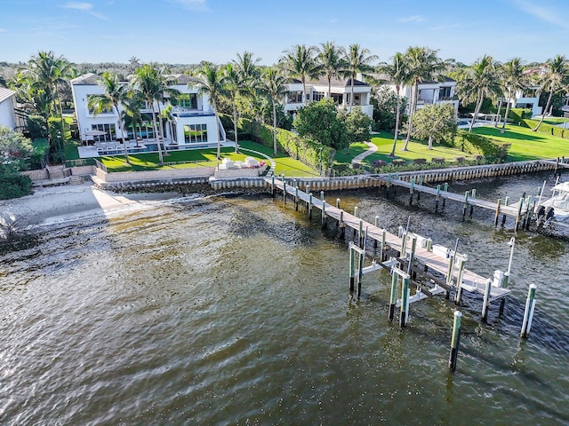 view of dock with a yard and a water view