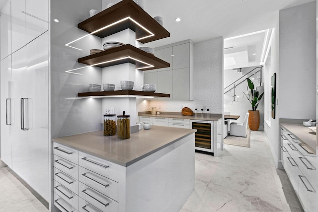 kitchen with white cabinets, decorative backsplash, and wine cooler