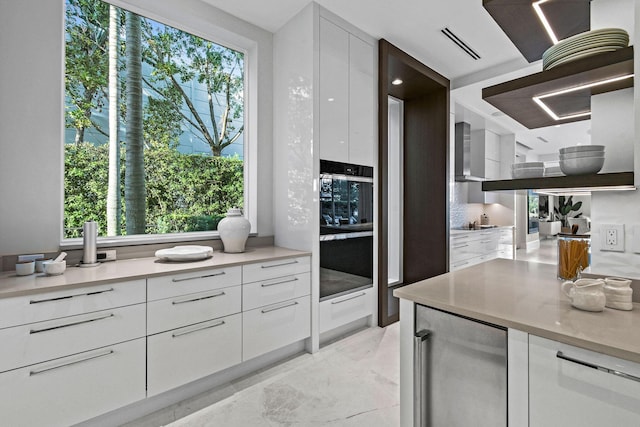 kitchen featuring wine cooler, white cabinetry, and a wealth of natural light