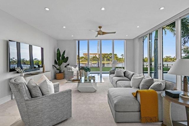 living room featuring ceiling fan and expansive windows