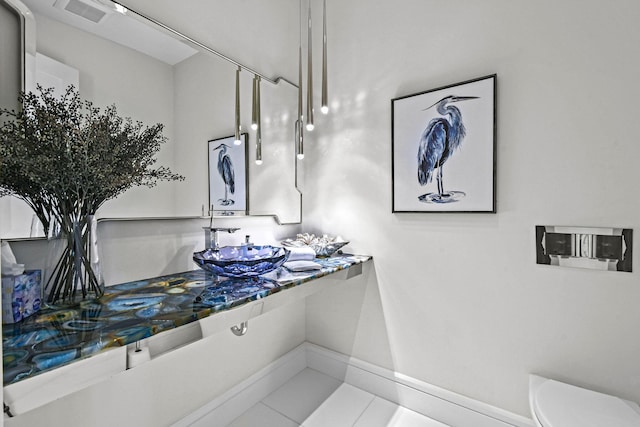 bathroom featuring toilet, sink, and tile patterned flooring