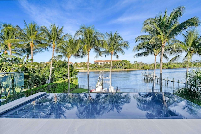 view of swimming pool featuring a boat dock and a water view