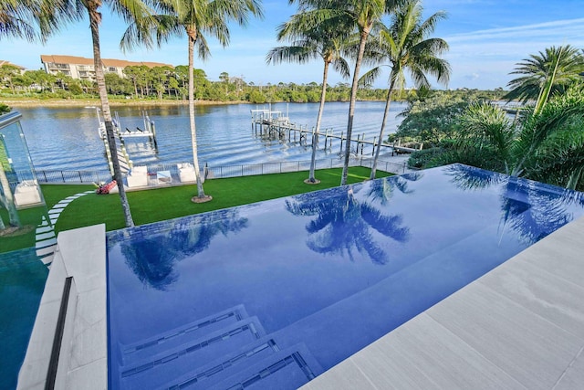 view of pool featuring a lawn, a water view, and a boat dock