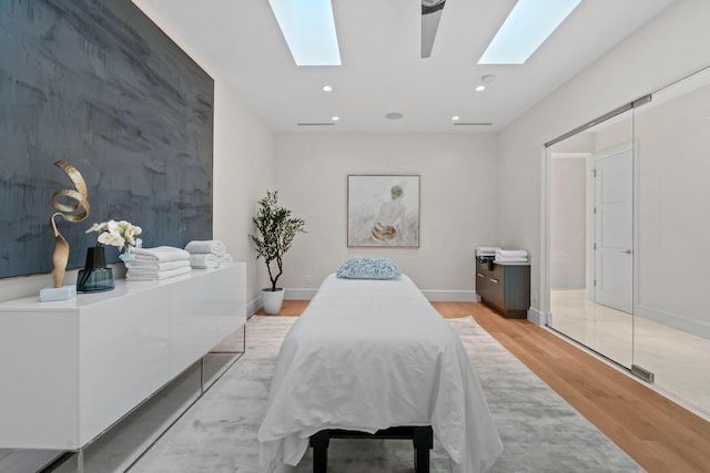 bedroom with light hardwood / wood-style floors and a skylight