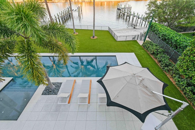 view of pool with a boat dock, a water view, and a yard