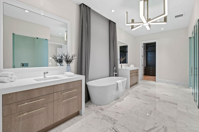 bathroom with a washtub, vanity, and an inviting chandelier