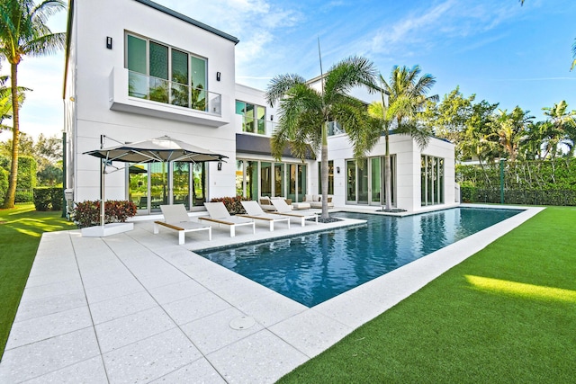 view of pool with a lawn and a patio