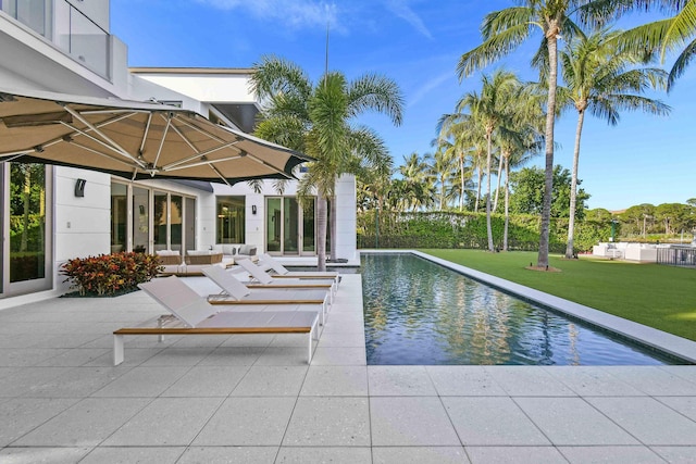 view of swimming pool featuring a yard and a patio area