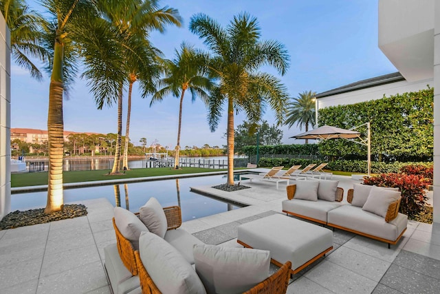 view of swimming pool featuring a patio and a water view