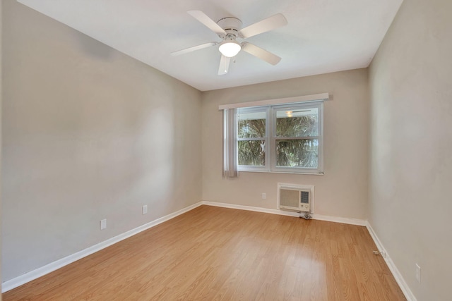 spare room featuring a wall mounted air conditioner, light hardwood / wood-style floors, and ceiling fan