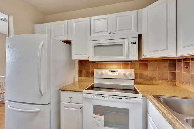 kitchen with tasteful backsplash, white cabinetry, sink, and white appliances