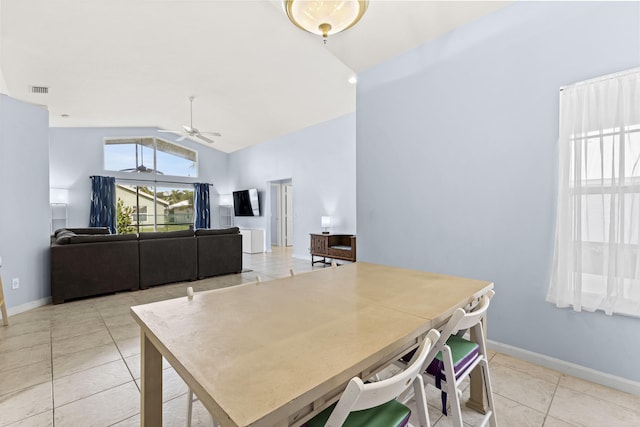 tiled dining area featuring ceiling fan and lofted ceiling