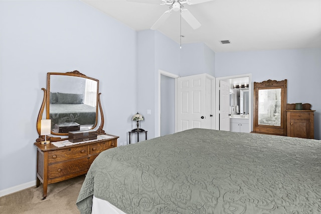 bedroom with ceiling fan, light colored carpet, connected bathroom, and vaulted ceiling