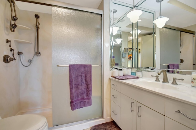 bathroom featuring vanity, toilet, and a shower with shower door