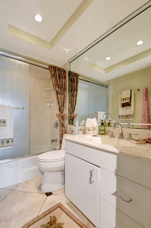 full bathroom featuring combined bath / shower with glass door, vanity, a tray ceiling, and tile patterned flooring