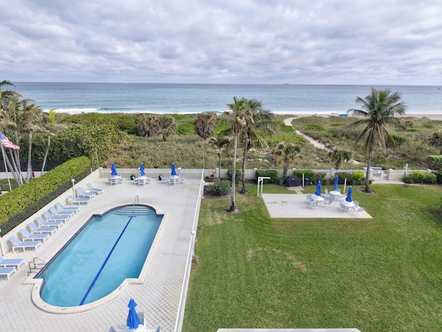 view of swimming pool with a water view, a patio area, and a lawn