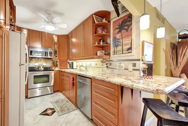 kitchen featuring backsplash, a kitchen breakfast bar, hanging light fixtures, kitchen peninsula, and stainless steel appliances