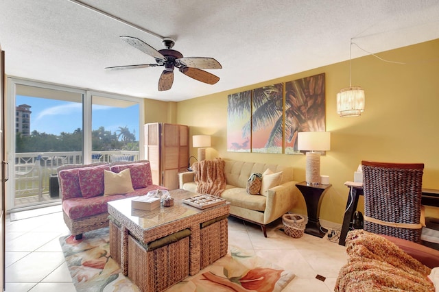 tiled living room featuring ceiling fan, a textured ceiling, and a wall of windows