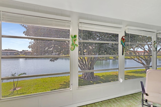 sunroom featuring a water view