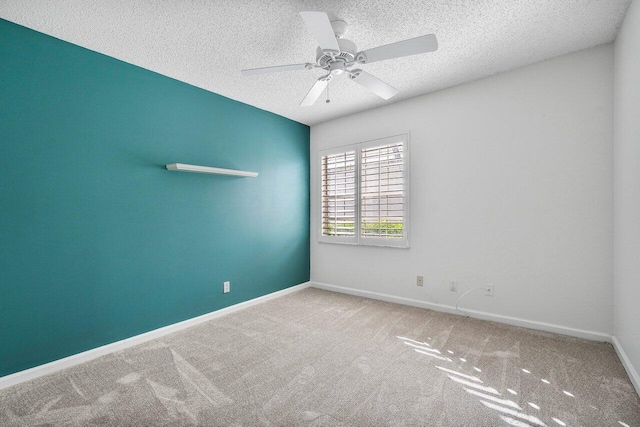 unfurnished room featuring ceiling fan, carpet, and a textured ceiling