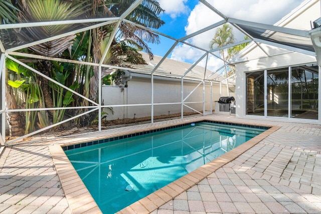 view of swimming pool with a patio and glass enclosure