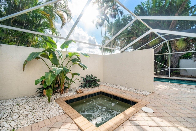 view of swimming pool with an in ground hot tub and a lanai