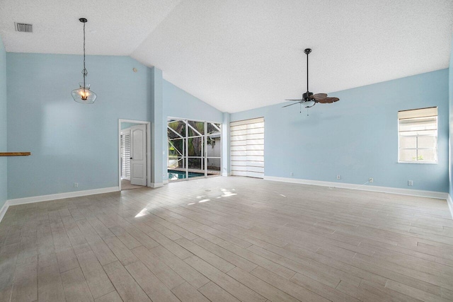 unfurnished living room with ceiling fan, light hardwood / wood-style floors, a textured ceiling, and vaulted ceiling