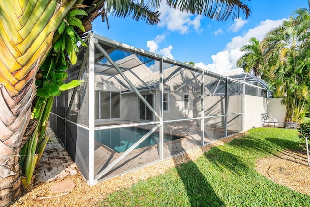 back of house featuring a lanai and a lawn