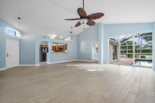 unfurnished living room with ceiling fan, a healthy amount of sunlight, and light wood-type flooring